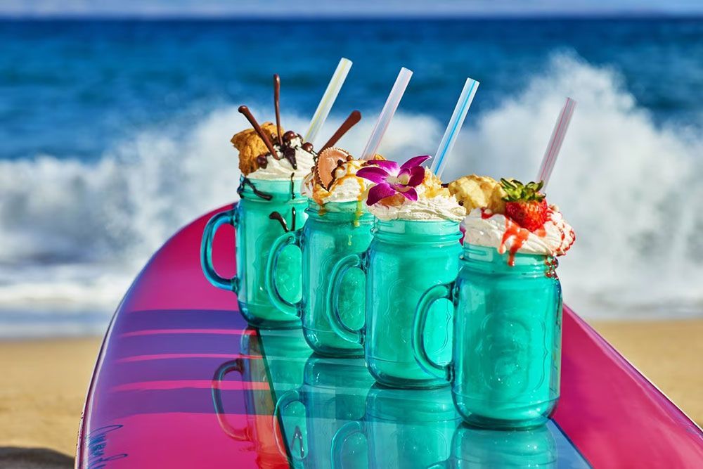 The Ritz-Carlton Maui, Kapalua milkshakes on surfboard, ocean waves crashing in the background